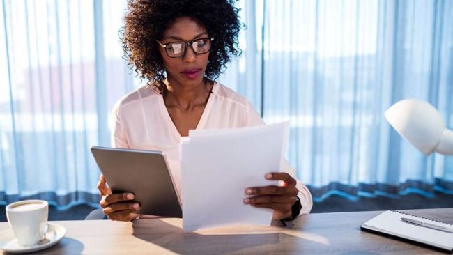woman with glasses revising documents
